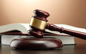 wooden gavel and books on wooden table,on brown background